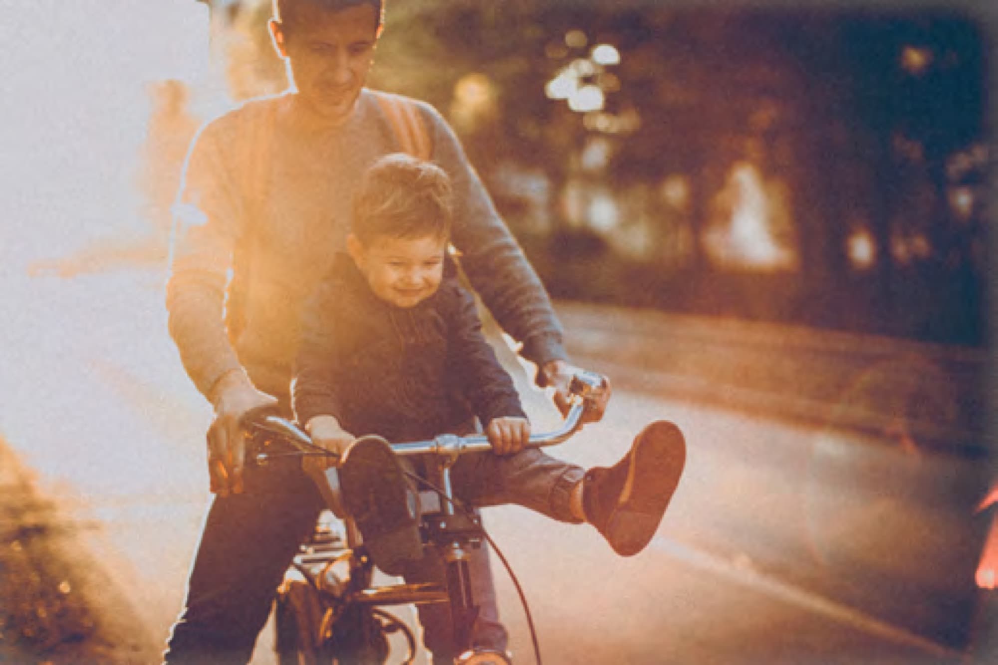 Father cycling with his son at dusk in Arabian Ranches 3. AR3 Living is your go-to local expert on getting around and commuting from the community.