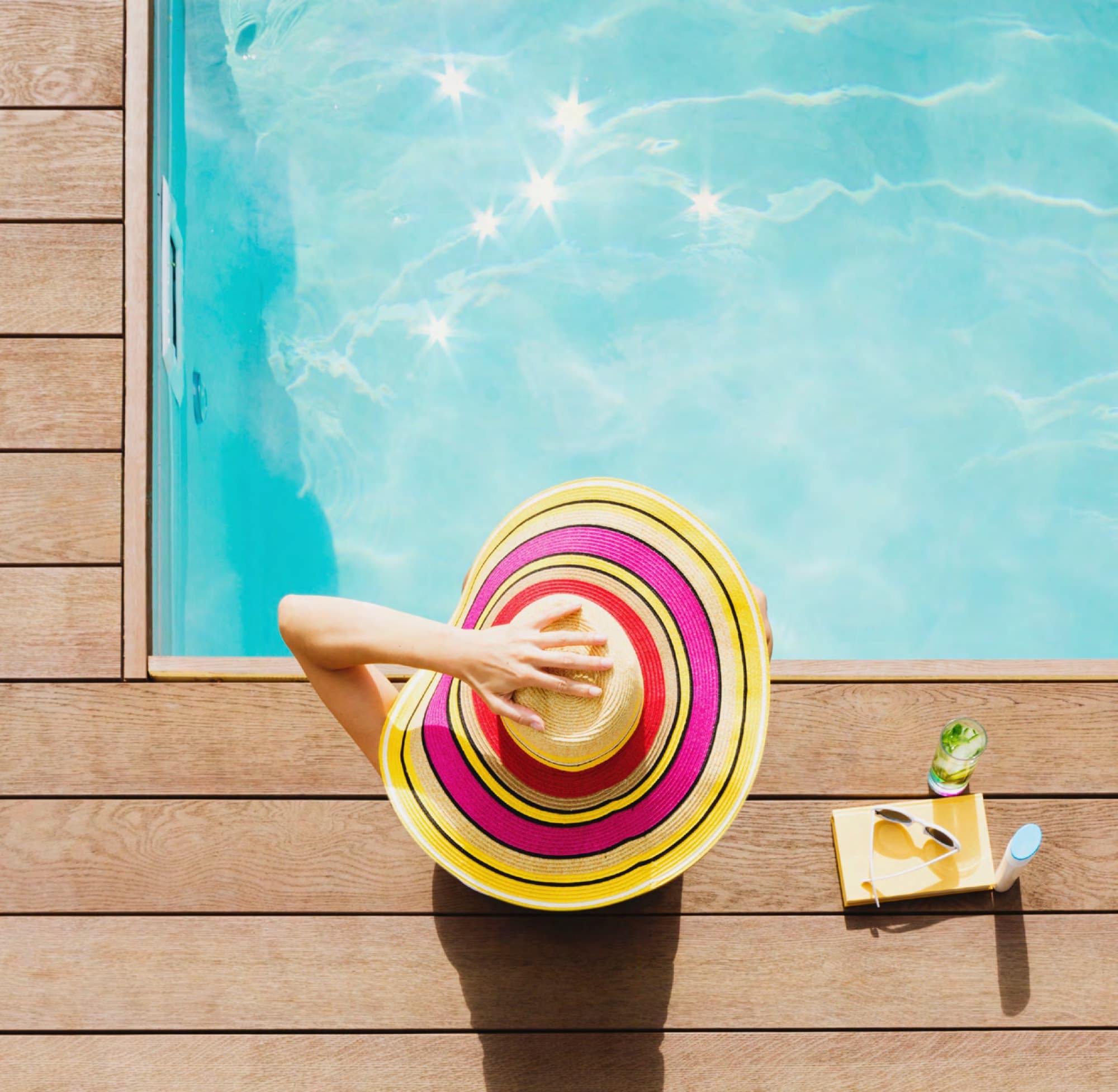 Woman relaxing on a pool deck, enjoying villa life in Arabian Ranches 3. AR3 Living is your go-to on-the-ground expert for mortgage advice.