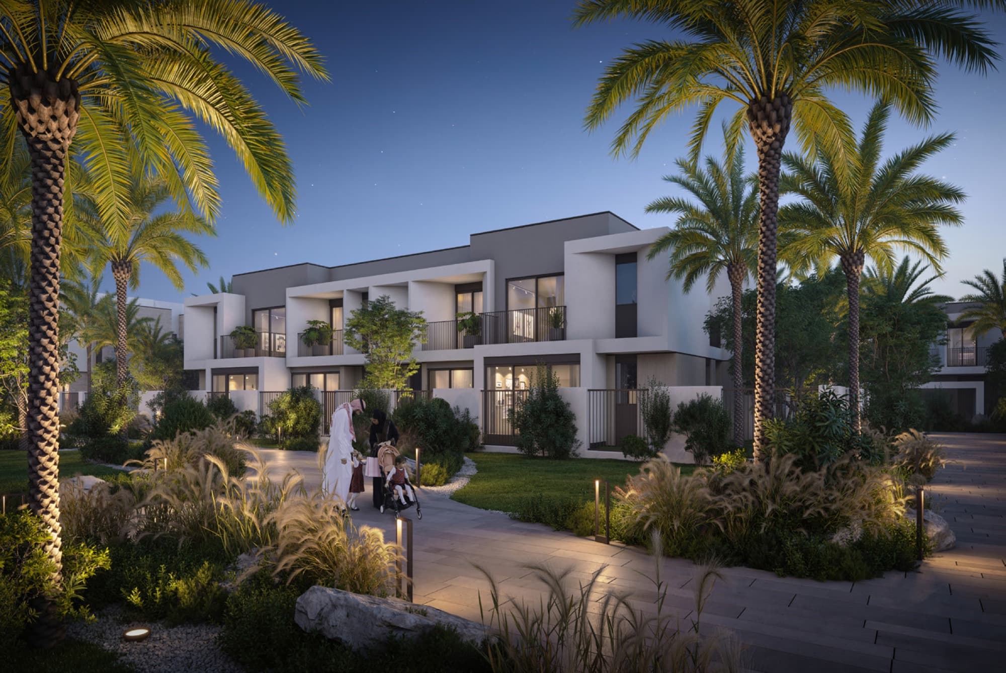 Evening exterior of Anya 2 townhouses, Arabian Ranches 3, with a family strolling past the dark-toned contemporary façade.