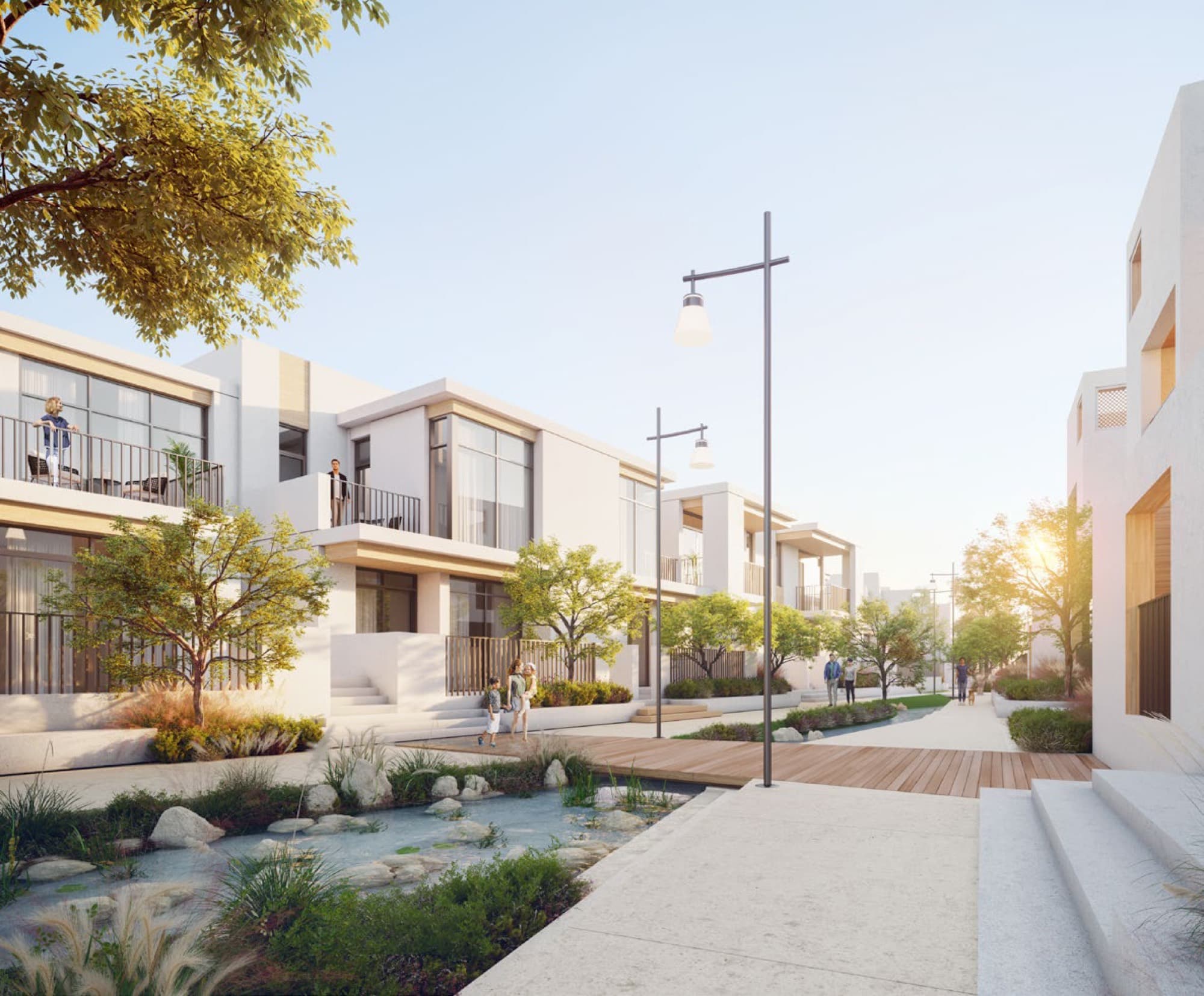 Contemporary dark-tone townhouses in Bliss, Arabian Ranches 3, Dubai, with a landscaped walkway and stream running between the rows.