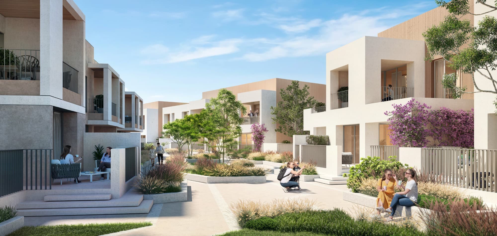 Street scene in Bliss 2, Arabian Ranches 3, Dubai, with contemporary cream-toned townhouses set behind landscaped courtyards.