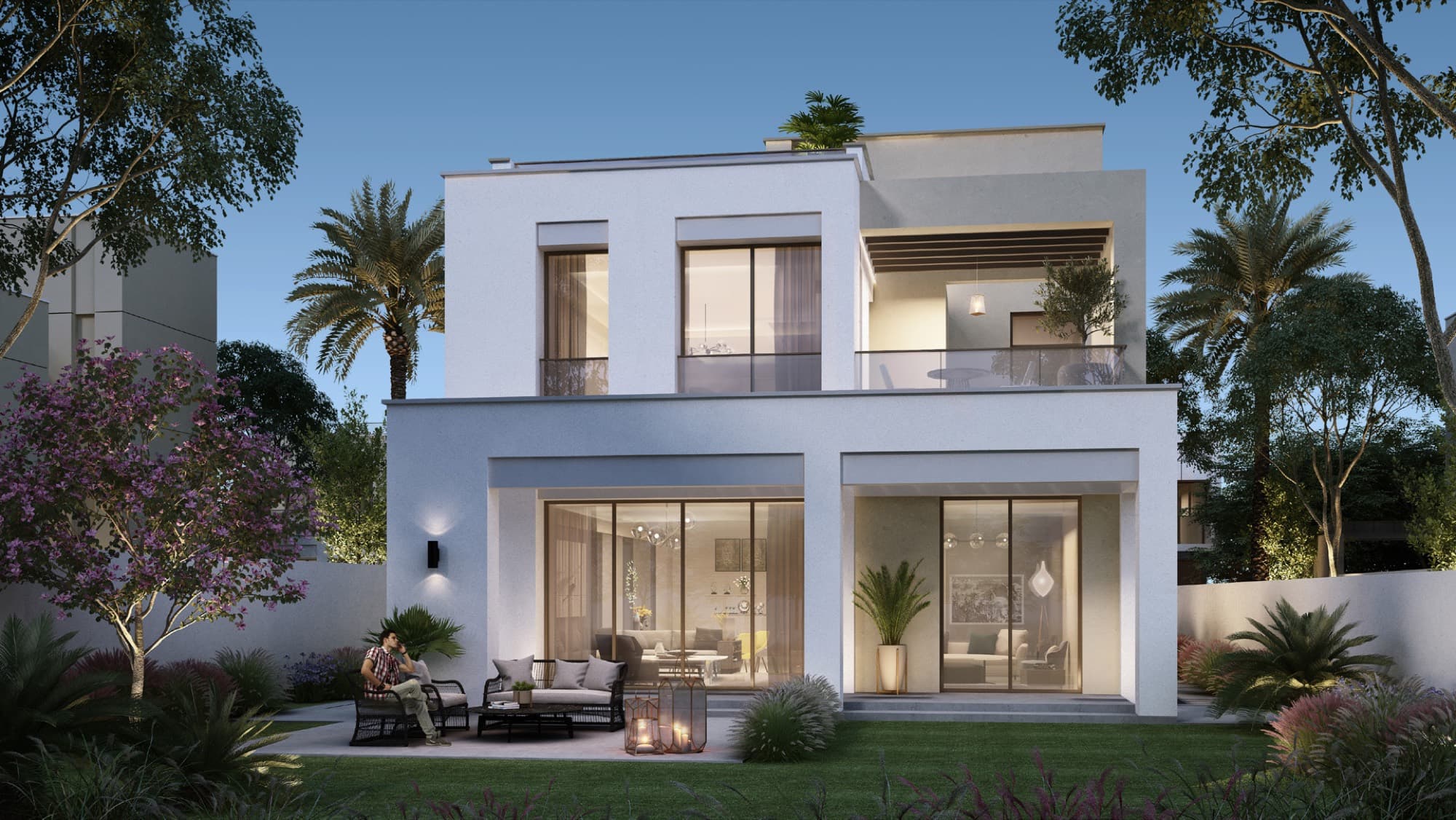 Rear garden of a Caya 2 villa in Arabian Ranches 3, Dubai, lit at night with an outdoor firepit lounge on the lawn.