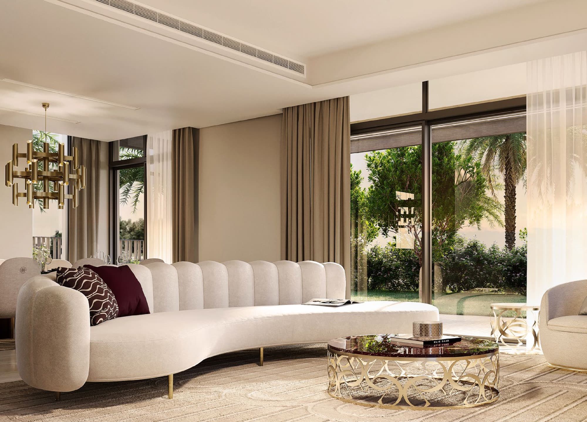 Living room in an Elie Saab villa, Arabian Ranches 3, with a curved cream sofa and gold pendant chandelier overlooking the garden.
