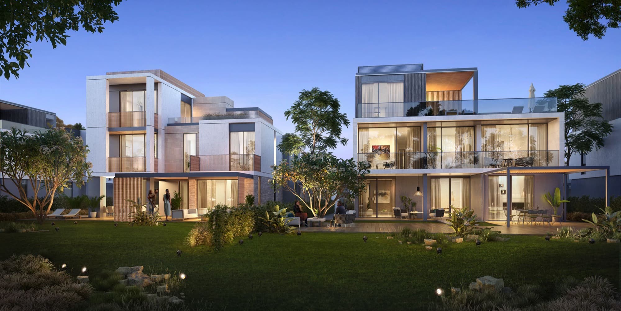 Dusk exterior of twin Elie Saab villas in Arabian Ranches 3, glass balconies and a landscaped garden terrace between them.