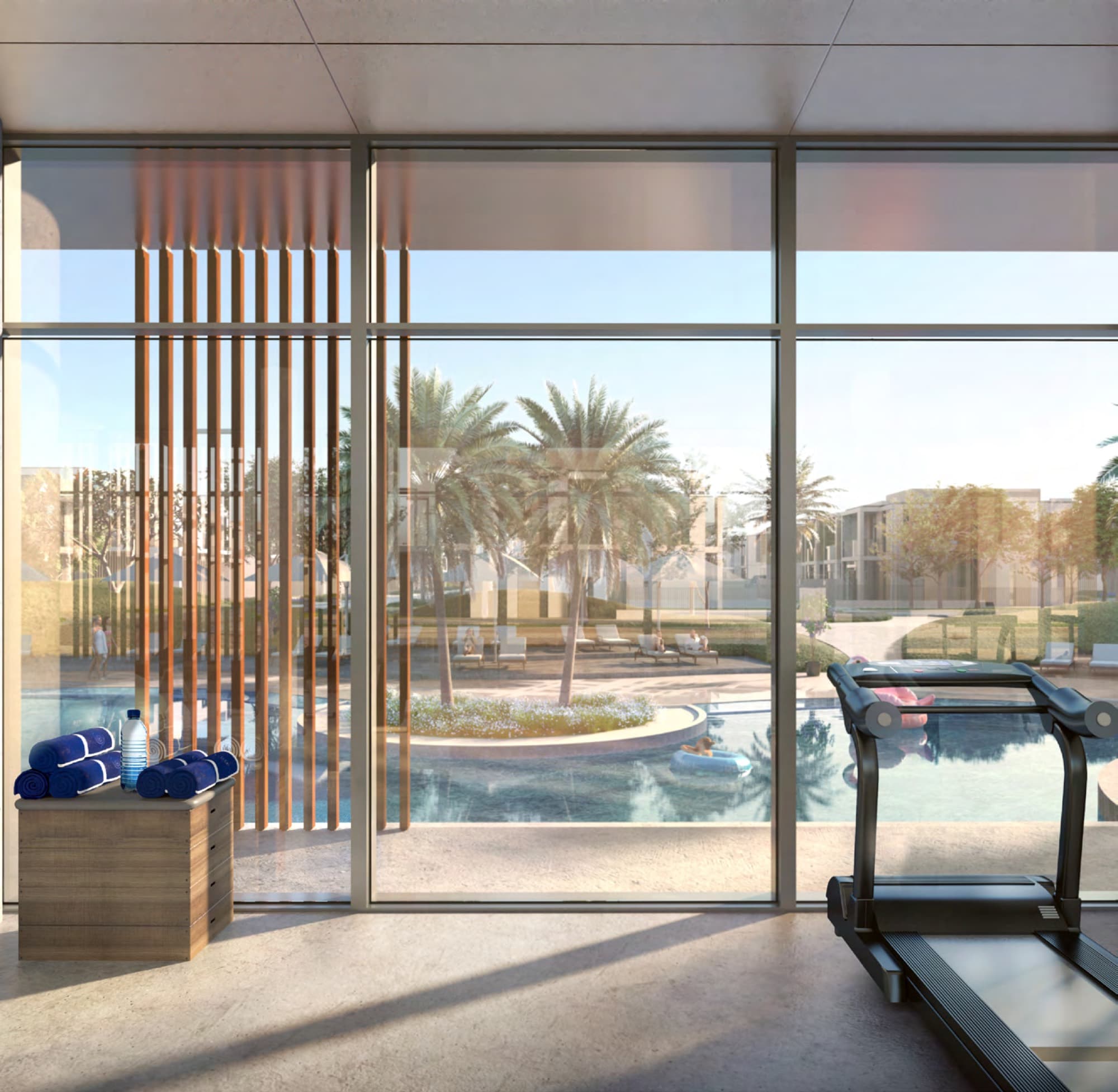 Gym with treadmills overlooking the swimming pool and palm trees at Ruba, Arabian Ranches 3, Dubai.