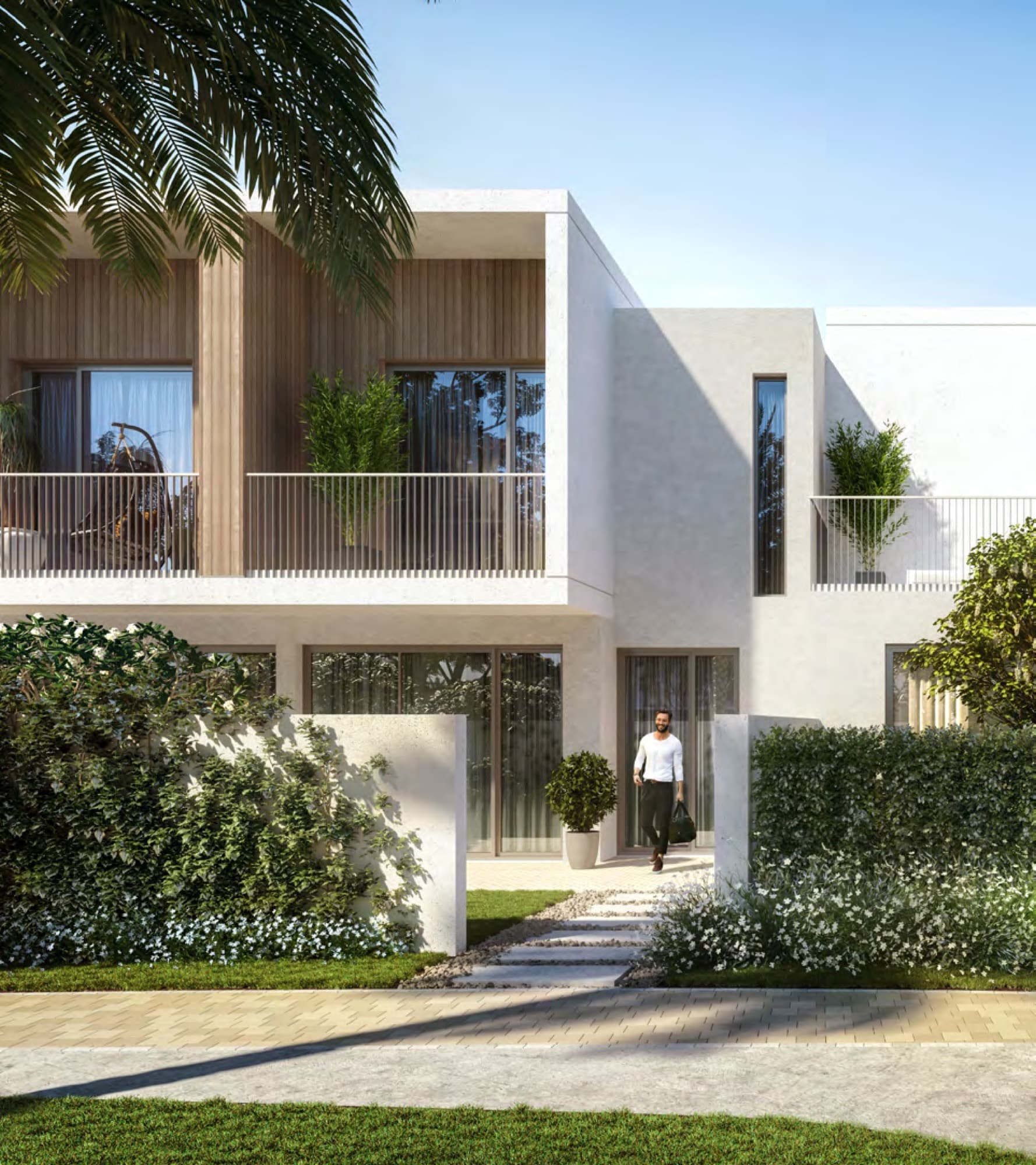 Man walking towards a Spring townhouse entrance past a timber-clad balcony, Arabian Ranches 3, Dubai.