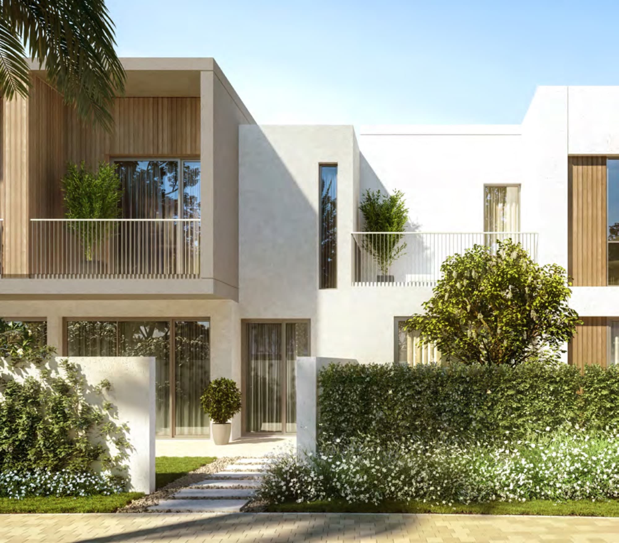 Close-up of a Spring townhouse façade with wood-panelled balcony and mature shrubs, Arabian Ranches 3, Dubai.