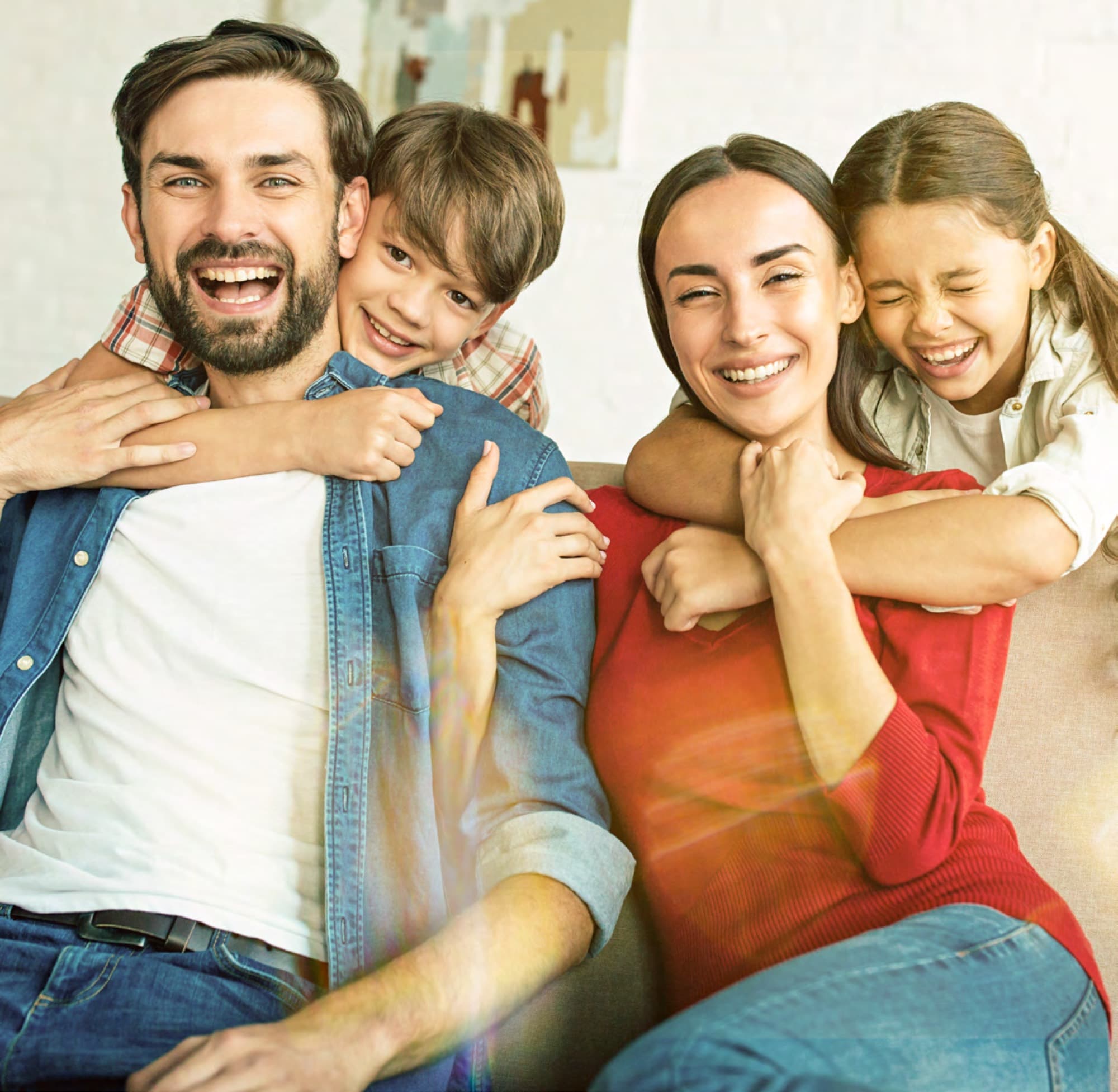 Family of four laughing together at home in Arabian Ranches 3. AR3 Living is your go-to on-the-ground expert for schools and nurseries near the community.